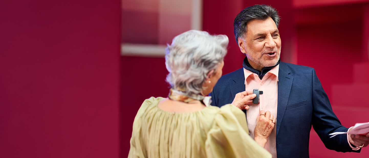 A man in a suit being fitted with a microphone